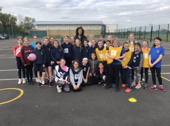 England international Serena Guthrie, back row, centre, visiting with youngsters from the Berko Belles team recently.