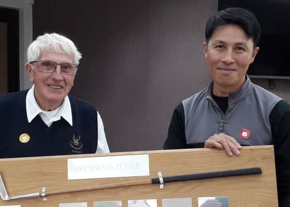 From left, Little Hay Golf Club President Ralph Lane presents Tong Tse with the Presidents Putter, which Tong has now won for three years on the trot.