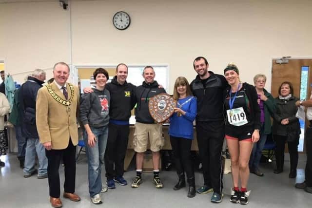 The Harriers collecting the winning team trophy at the Abbots Langley Tough Ten event.