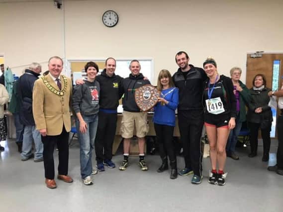 The Harriers collecting the winning team trophy at the Abbots Langley Tough Ten event.