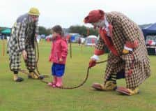 Three-year-old Lexi Foulger joins in with the clowns Sonny and Rainbow