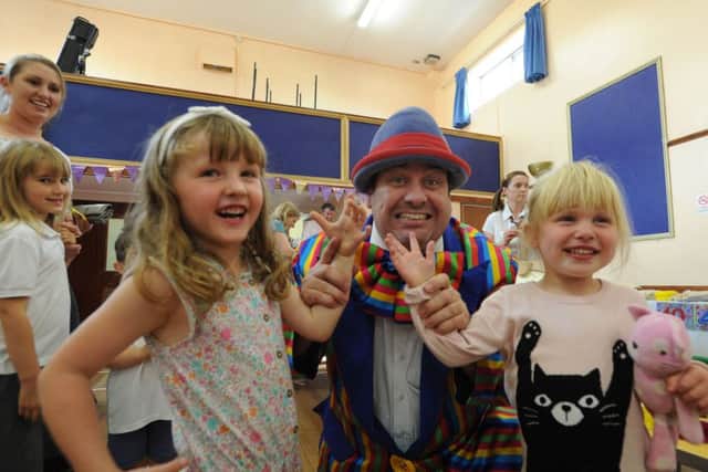 Leverstock Green Playgroup is 40 years old.
Stripey Wipey the clown with Mia Hatswell , three, and Lucy Gray, two.