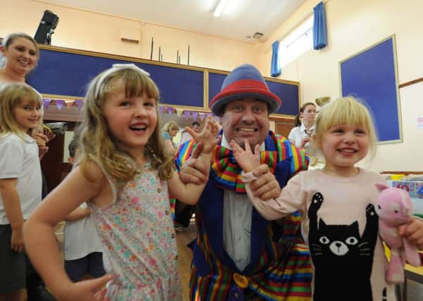 Leverstock Green Playgroup is 40 years old.
Stripey Wipey the clown with Mia Hatswell , three, and Lucy Gray, two.