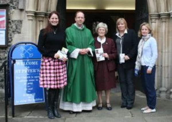 Representatives from three charities and Father Tom Plant at St Peter's