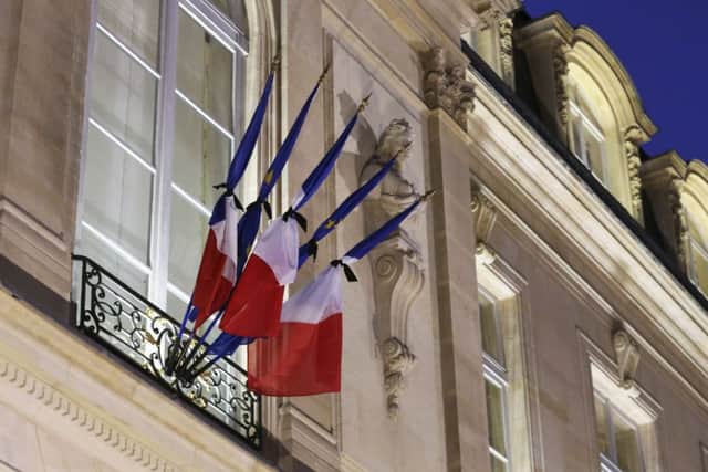 Flags are tied up with black ribbons as French President Francois Hollande meets with government members at the Elysee Palace in Paris after the terrorist attack against satirical newspaper Charlie Hebdo. AP Photo/Remy de la Mauviniere