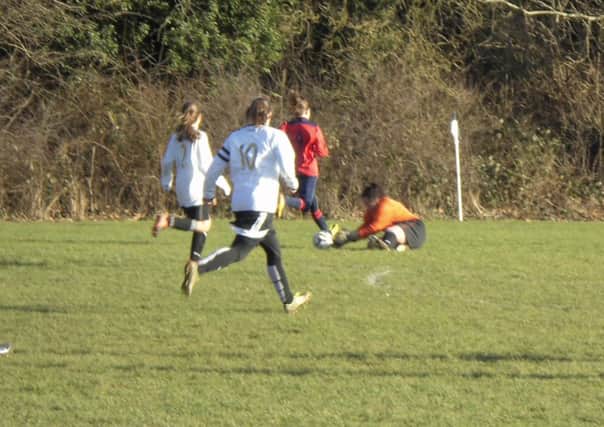 Kings Langley Ladies keeper Abbie Tarsey gets down at the feet of an Owls attacker