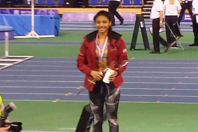 Jess Robinson stands proudly on top of the podium