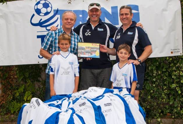 Derek Williams, Greg Cox (director of Tring Tornadoes Charity) and Stephen Bailey join young Tornadoes players in making the kit donation. Picture (c) Vanessa Champion