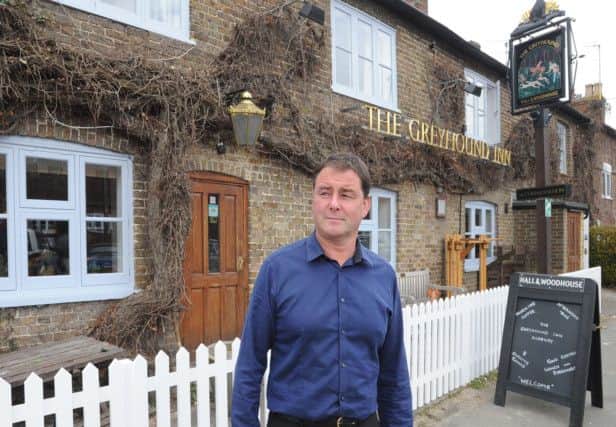 Landlord Tim O'Gorman and the new windows of The Greyhound, Aldbury.