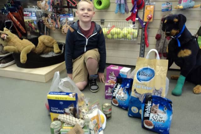 Harvey Lewis, nine, with some of the animal food he got from friends after asking for donations instead of birthday presents