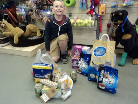 Harvey Lewis, nine, with some of the animal food he got from friends after asking for donations instead of birthday presents