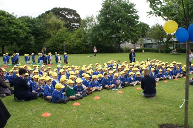 Pupils gather for the tea party on the school field, where seven new trees were planted