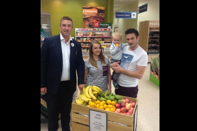 Store manager Roly Lumm, with customers Poppy Standley and Bruce Russell with 18 month old Finley.