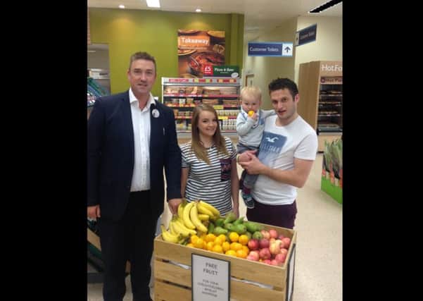 Store manager Roly Lumm, with customers Poppy Standley and Bruce Russell with 18 month old Finley.