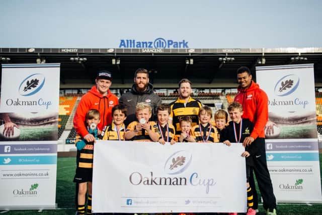 Saracens players Nick Tompkins (in red), Will Fraser, and Nathan Earle joined Aaron Kibble (manager of The Akeman) to present the Tring juniors with their prizes