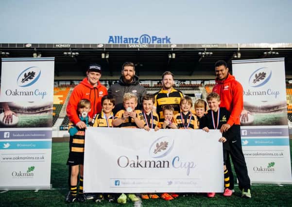 Saracens players Nick Tompkins (in red), Will Fraser, and Nathan Earle joined Aaron Kibble (manager of The Akeman) to present the Tring juniors with their prizes