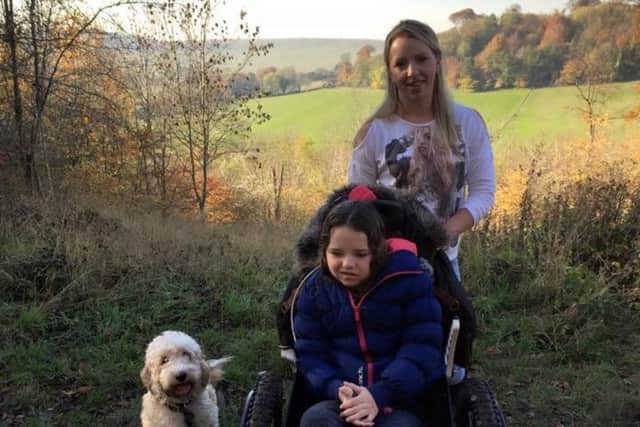 Sienna Hollick, nine, with her new wheelchair on a trip to Ashridge. Pictured with mum Becky, 32, and their dog Max.