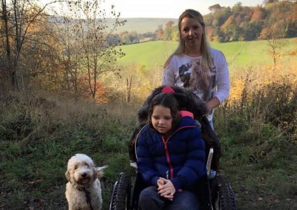 Sienna Hollick, nine, with her new wheelchair on a trip to Ashridge. Pictured with mum Becky, 32, and their dog Max.