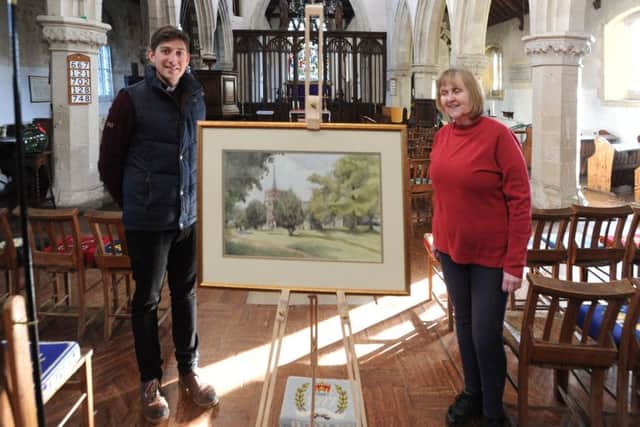St Leonard's vicar Tom Saunders and late artist Peter Wagon's daughter Sally with a painting by her father