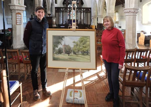 St Leonard's vicar Tom Saunders and late artist Peter Wagon's daughter Sally with a painting by her father