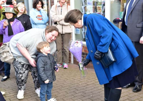Bradley Walker, three, hands Princess Anne a bouquet on her visit to the Save The Children charity shop in Tring. Photo by Stephen Kitchener