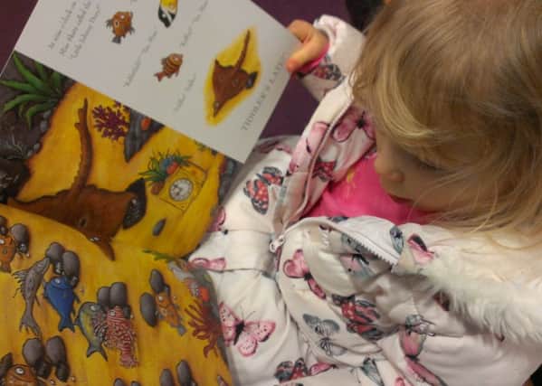Child reading a book (stock image)