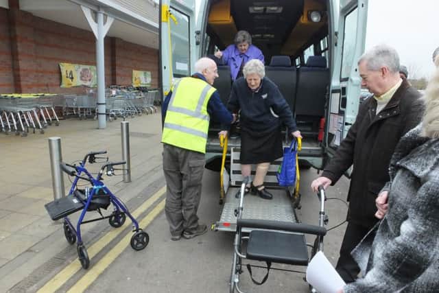 Passengers disembark from the Door to Store minibus