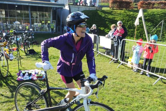 Elaine Bunn grabs her bike for the cycling leg after a 400m swim, with supporters cheering her on