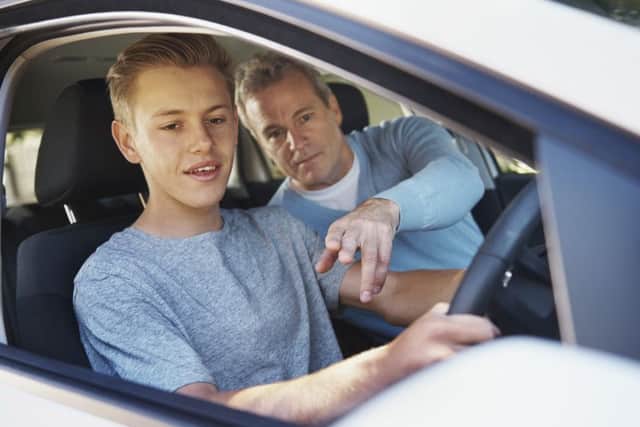 A father teaching his teenage son to drive