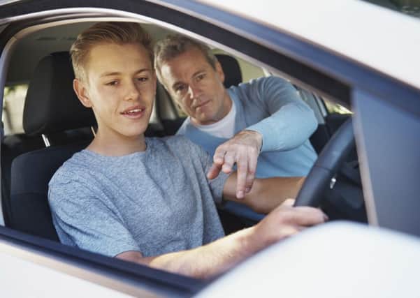 A father teaching his teenage son to drive