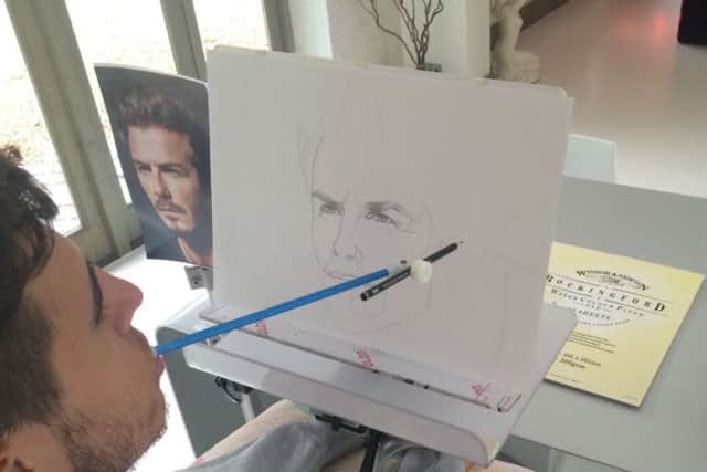 Henry Fraser at work, drawing a picture of David Beckham