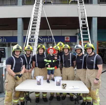 Hemel Hempstead firefighters staged a ladder climb in the Marlowes on Saturday for James Maguire, aged three. James is pictured with the firefighters.