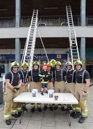 Hemel Hempstead firefighters staged a ladder climb in the Marlowes on Saturday for James Maguire, aged three. James is pictured with the firefighters.