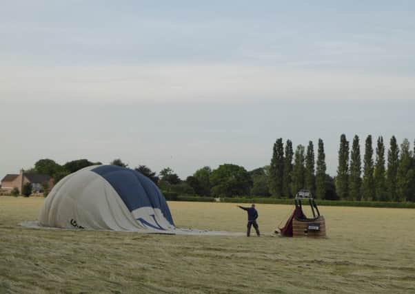 Hot air balloon on a field of hay.  Picture copyright Heather Jan Brunt