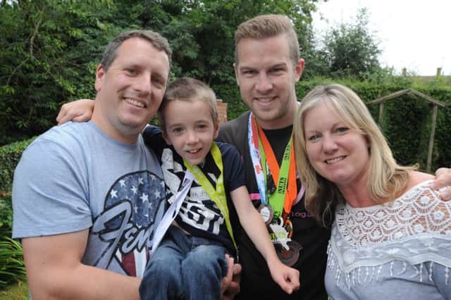 James Dodd, seven, mum Angela Barton and dad Iain Dodd meets multi athlete Neil Harper,in black T-shirt, in Hemel Hempstead on Monday.