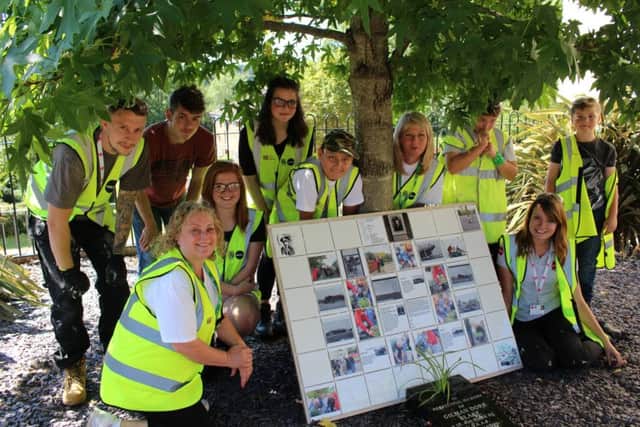 Young people help create a mural for the memorial garden at Gade Tower
