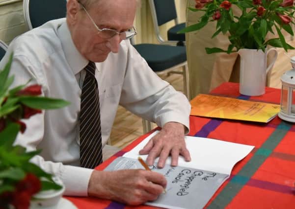 Alan Taylor signs a copy of his book