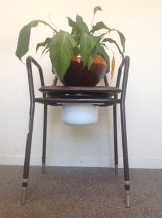 A commode being used as a plant stand