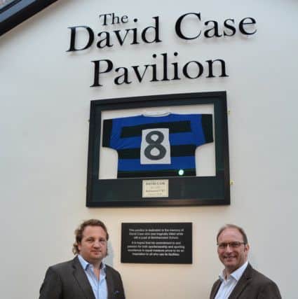 Andi and Richard Case beneath the framed rugby shirt worn by their brother, David