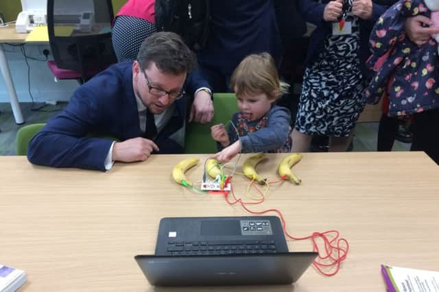 Young library visitor teaches the minister banana piano