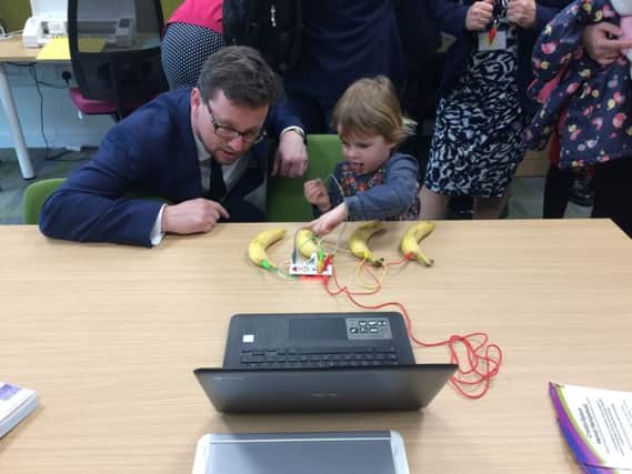 Young library visitor teaches the minister banana piano