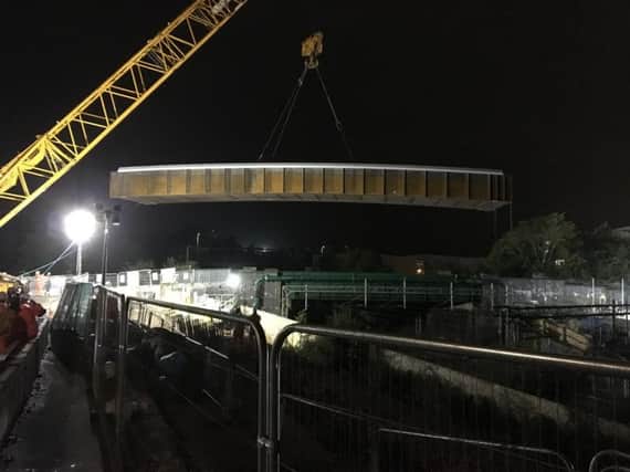The bridge is lifted into place over Featherbed Lane