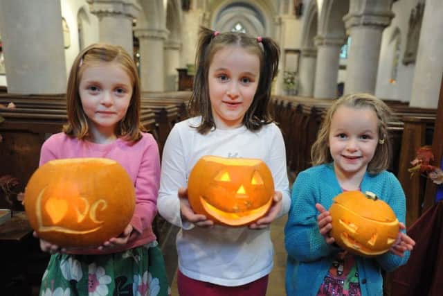 Anabel Tabiello six, Ellie Michaels five, and Rosa Michaels four, with good will pumpkins in St. Mary's Church